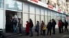Люди стоят в очереди, чтобы снять деньги в банкомате Альфа-банка в Москве. 27 февраля 2022 года. Россияне устремились к банкам и банкоматам вскоре после того, как Россия начала атаку на Украину, а Запад объявил суровые санкции