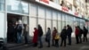 Russia - People stand in line to withdraw money from an ATM of Alfa Bank in Moscow, Russia, Sunday, Feb. 27, 2022. Russians flocked to banks and ATMs shortly after Russia launched an attack on Ukraine and the West announced crippling sanctions. (AP Photo/