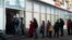 Russia - People stand in line to withdraw money from an ATM of Alfa Bank in Moscow, Russia, Sunday, Feb. 27, 2022. Russians flocked to banks and ATMs shortly after Russia launched an attack on Ukraine and the West announced crippling sanctions. (AP Photo/