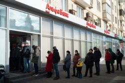 Oamenii stau la coadă pentru a retrage bani de la bancomat pe 27 februarie 2022, la trei zile de la invazia Rusiei în Ucraina.