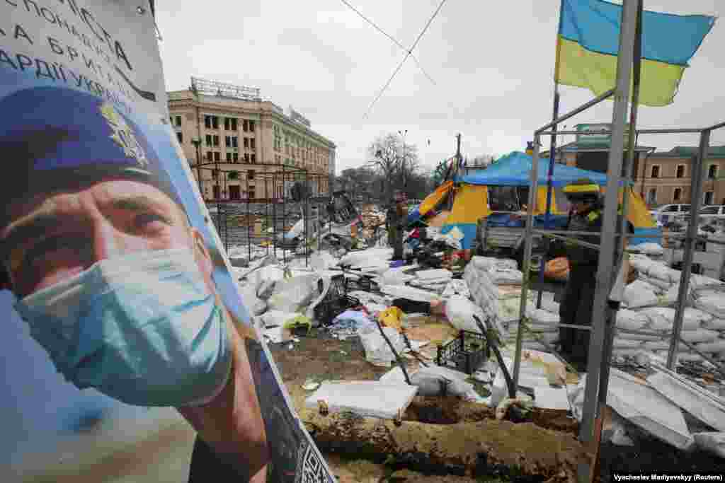 Ukrainian service members stand guard outside the regional administration building in Kharkiv, which city officials said was hit by a missile attack, on March 1.