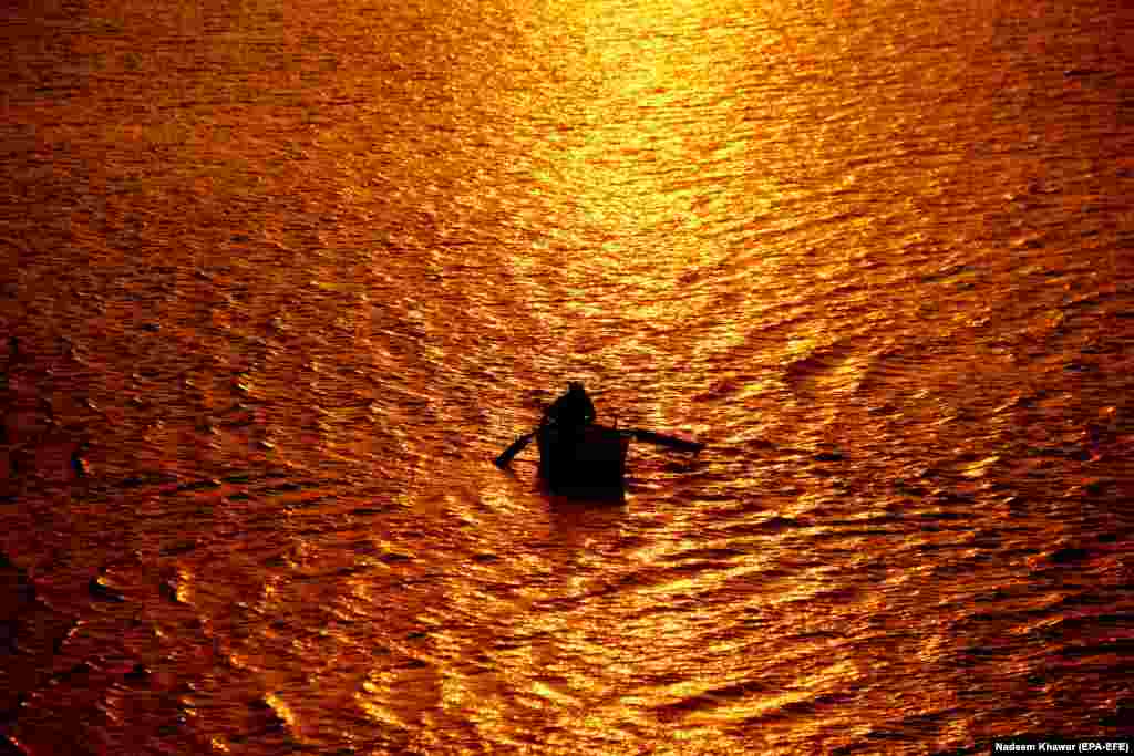 A man rows his boat on waters bathed in gold at sunset in Hyderabad, Pakistan. (epa-EFE/Nadeem Khawar)