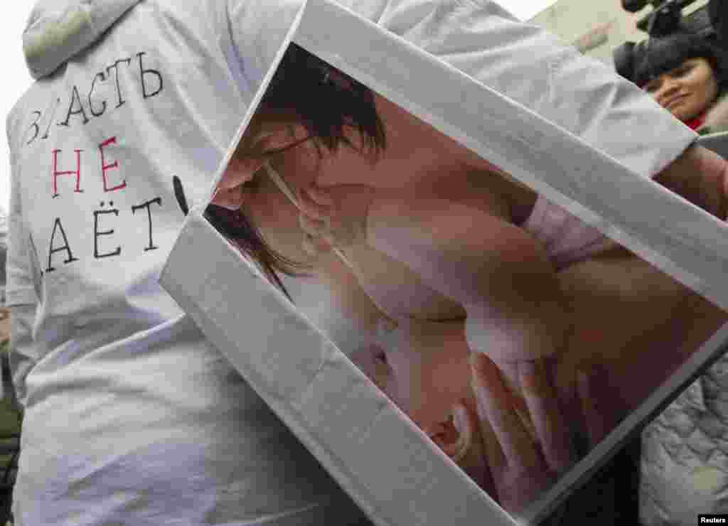 Almatıda etiraçı qadının gəzdirdiyi qutu 