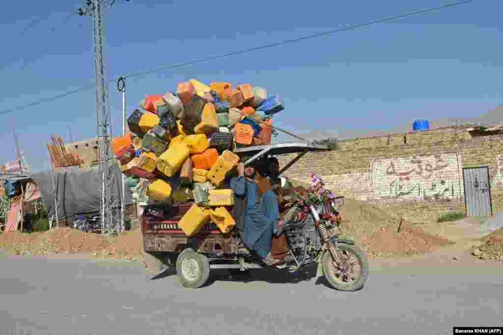 Pakistan workers transport plastic containers on a vehicle in Quetta.