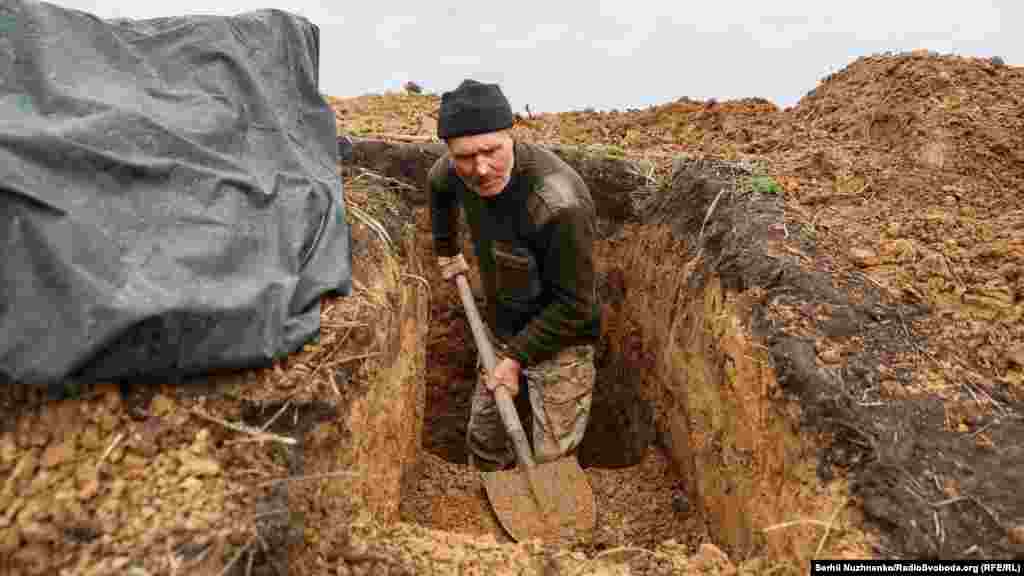 Український військовий копає траншею на передній лінії оборони Донецької області, 18 квітня 2022 року