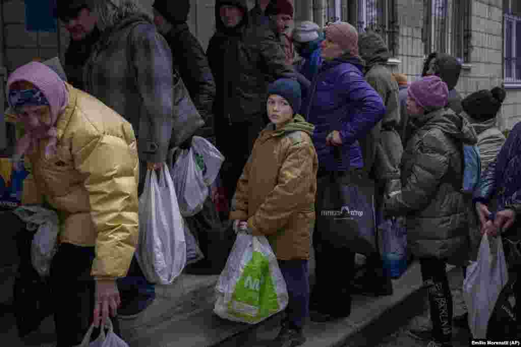 A 11 éves Szergej várja, hogy sorra kerüljön egy ételosztáson Bucsában április 19-én. A város lakói több mint 44 nappal az orosz invázió kezdete óta áram, víz és gáz nélkül kénytelenek élni