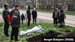 A funeral for a local resident killed in Russian shelling is held on a street in Mariupol on April 19.