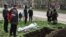 A funeral for a local resident killed in Russian shelling is held on a street in Mariupol on April 19.