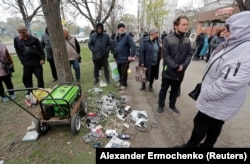 Residents wait for their devices to be charged from a portable generator at a local market during in the southern port city of Mariupol.