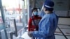 Radnik u zaštitnom odijelu mjeri tjelesnu temperaturu tokom sesije vakcinacije protiv korona virusa (COVID-19) za starije osobe, u društvenom centru za zdravstvene usluge u okrugu Fengxian u Šangaju, Kina, 21. aprila 2022. 