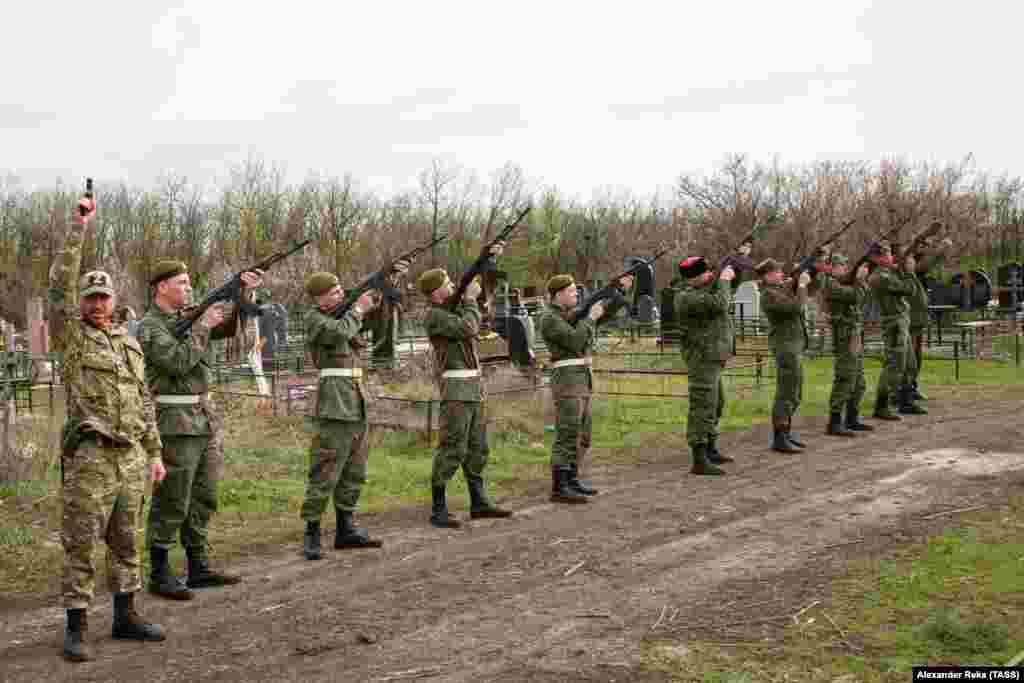 Russia-backed separatist fighters from the Luhansk region fire a salute during a funeral for a commander on April 19.&nbsp;