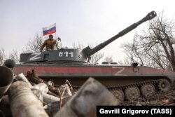 Russia-backed separatists are seen on a 2S1 Gvozdika self-propelled howitzer in the Luhansk region in March.