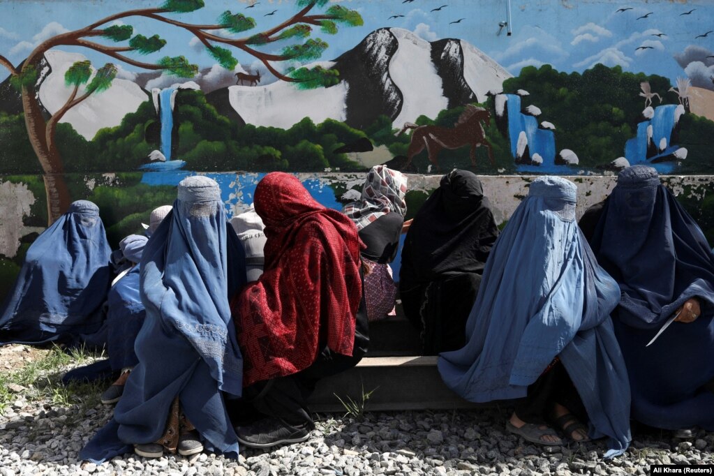 Afghan women wait to receive a food package being distributed by a Saudi humanitarian aid group at a distribution center in Kabul in April.