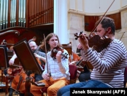 Oleksiy Pshenychnikov (në mes) dhe muzikantë të tjerë të instrumenteve me harqe gjatë provës në Varshavë.