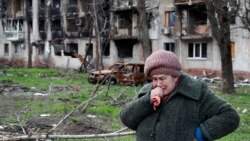 Tamara, o femeie de 71 de ani, plânge în fața blocului din Mariupol în care locuia înainte ca orașul să fie distrus de forțele rusești. 