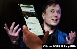Në këtë ilustrim fotografik, një ekran telefoni shfaq llogarinë në Twitter të Elon Muskut me një foto të tij të shfaqur në sfond, më 14 prill 2022.