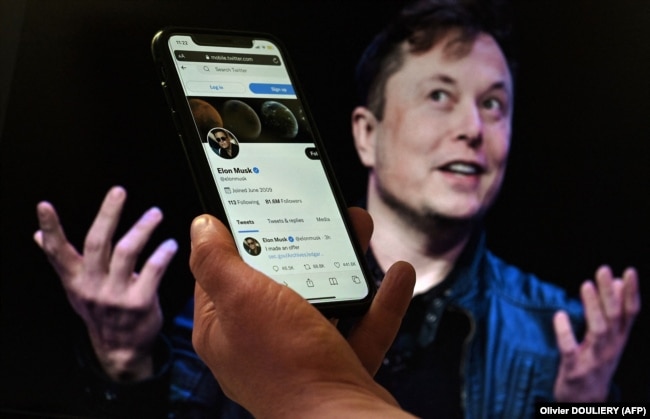 Në këtë ilustrim fotografik, një ekran telefoni shfaq llogarinë në Twitter të Elon Muskut me një foto të tij të shfaqur në sfond, më 14 prill 2022.