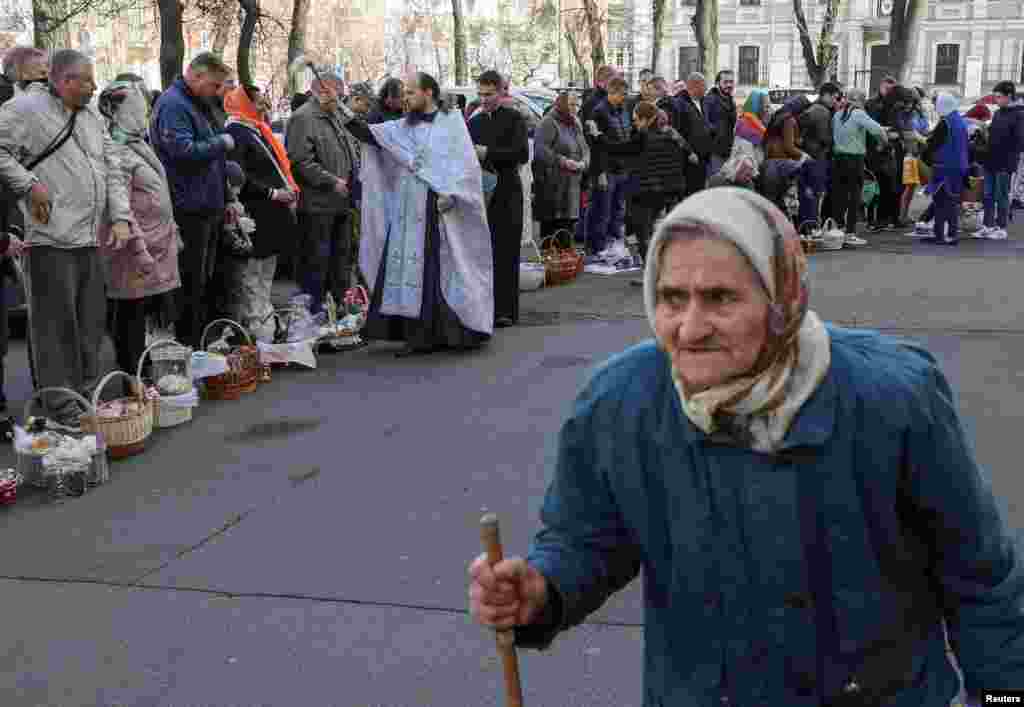Një prift ortodoks spërkat me ujë të shenjtë besimtarët gjatë shërbimeve për Pashkët Ortodokse jashtë Katedrales Volodymysky në Kiev. &nbsp;
