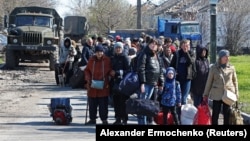 Evacuees wait before boarding a bus to leave the city of Mariupol on April 20. 