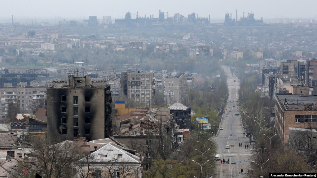 Damaged buildings are pictured in Mariupol on April 19, with the Azovstal steel works plant in the background.