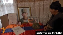 Armenia - The mother of Kyaram Sloyan, an Armenian soldier killed and decapitated by Azerbaijani troops in Nagorno-Karabakh, looks at his photogaphs, Artashavan, 10Apr2016.