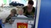Жінка голосує на пересувній виборчій дільниці під час незаконних місцевих виборів, організованих встановленою Росією владою в Донецьку, 6 вересня 2023 року