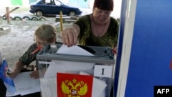A woman casts her ballot at a mobile polling station during local elections organized by the Russian-installed authorities in Donetsk, Russian-controlled Ukraine, on September 6, 2023.