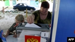 Egy nő szavaz egy mobil urnánál az orosz hatóságok által szervezett előrehozott helyhatósági választásokon az orosz ellenőrzés alatt álló ukrajnai Donyeckben 2023. szeptember 6-án