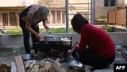 Local residents cook food in a street in Stepanakert in Nagorno-Karabakh on September 22. As Baku's forces tighten their grip on the breakaway Azerbaijani region, concern has been mounting over the plight of ethnic Armenian civilians trapped there.