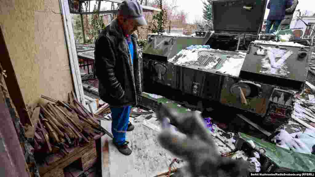 Erkek arbiy maşina yanında yatqan Rusiye askeriniñ cesedine baqa, Buça, Kyiv vilâyeti, 2022 senesi martnıñ 1-i