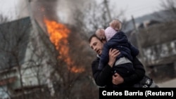 Otac bježi sa djetetom iz Irpina nakon što je jedna ruta za bijeg bombardovana, 6. marta 2022.