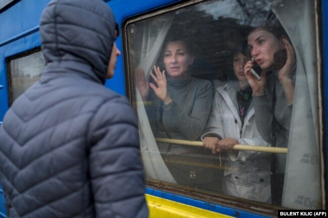 Члены семьи в эвакуационном поезде прощаются с оставшимся молодым человеком на центральном вокзале в Одессе 6 марта. Государственная железная дорога ежедневно перевозит около 60 000 украинцев с юга, севера и востока страны в пункты назначения Запад.