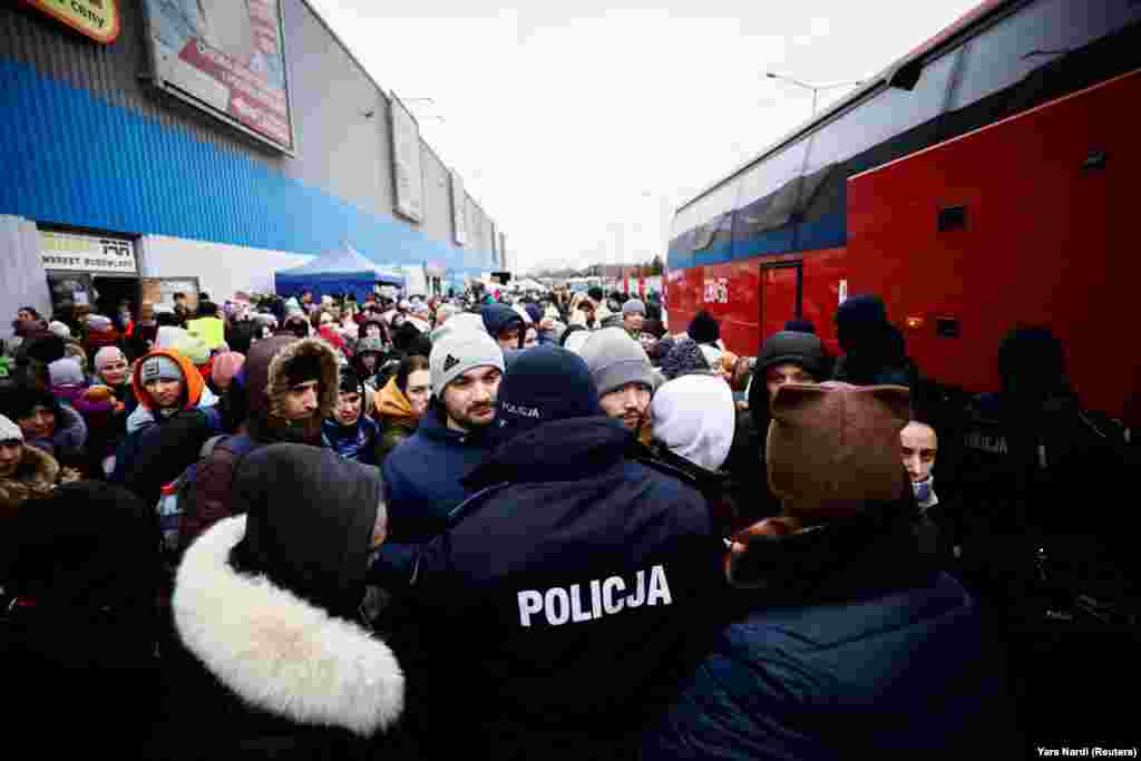 Rendőrök próbálják irányítani a tömeget, akik buszra várnak Korcsovában, hogy elmenekülhessenek Ukrajnából