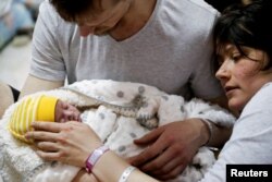 Egy házaspár újszülött gyermekével egy szülészeti klinika pincéjében berendezett óvóhelyen március 2-án