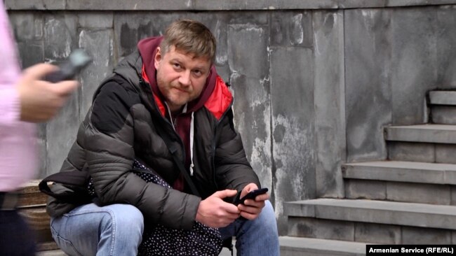 Një shtetas rus duke lexuar lajme në telefonin e tij. Jerevan, 4 mars 2022.