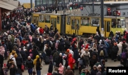 În 8 martie, la Lvov, refugiații așteaptă ore întregi îmbarcarea în trenuri care pleacă spre Polonia.