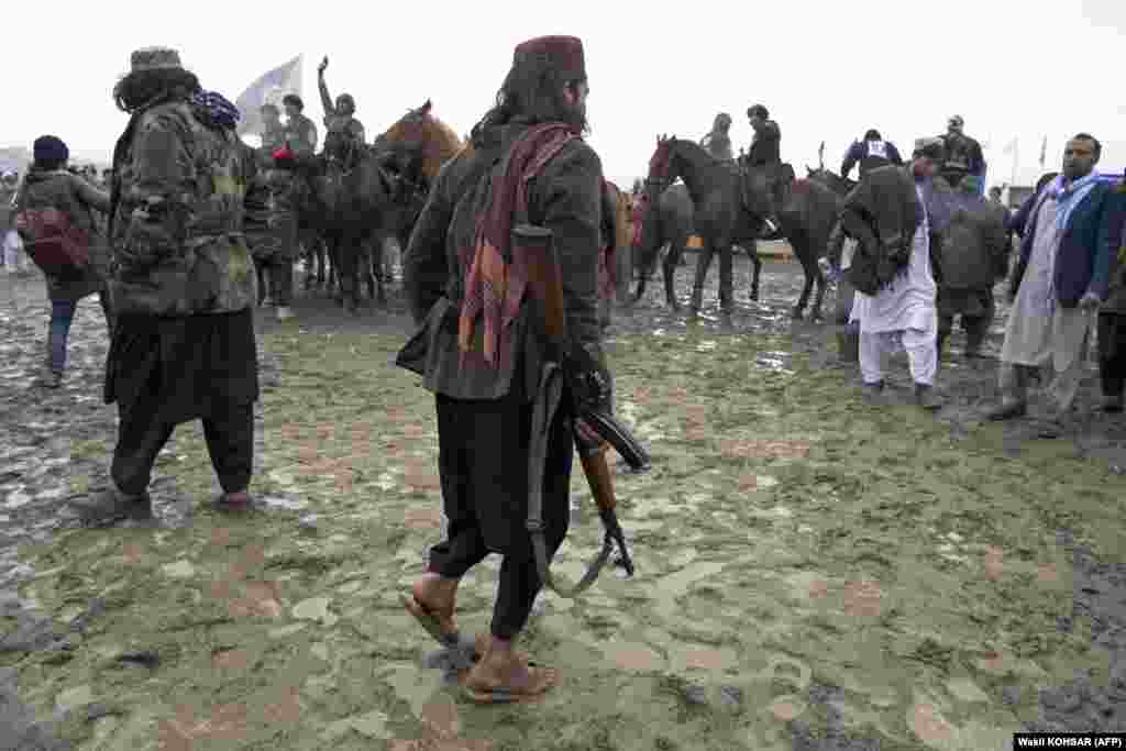 Taliban fighters stand near horsemen from the Kandahar and Kunduz teams during the final of Afghanistan&#39;s Buzkashi League in Kabul.&nbsp;
