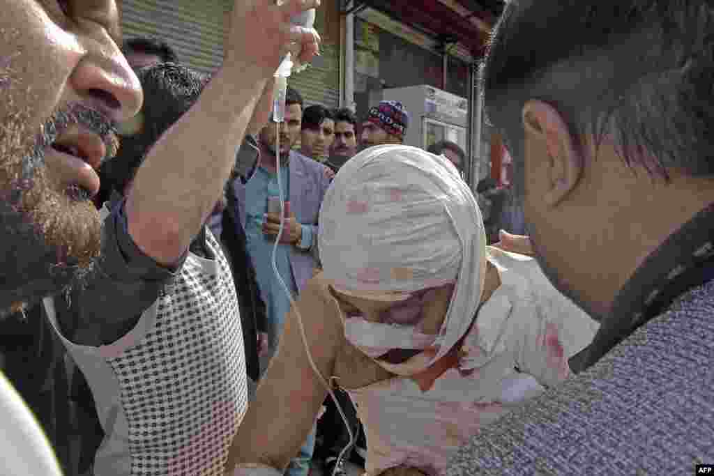 Ljudi pomažu povrijeđenom čovjeku ispred bolnice nakon eksplozije bombe u džamiji u Pešavaru 4. marta 2022.