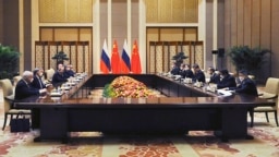 Chinese President Xi Jinping (fourth from right) and Russian President Vladimir Putin (fourth from left) attend a joint meeting in Beijing on February 4 where they declared a "no limits" partnership.