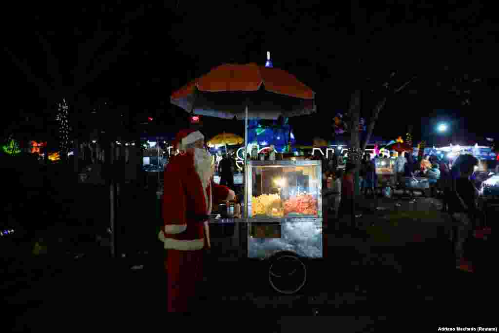 Një shitës pupagjelash i është bahskuar atmosferës festive duke u veshur si Babadimër, Brazil 11 dhjetor 2024.&nbsp;