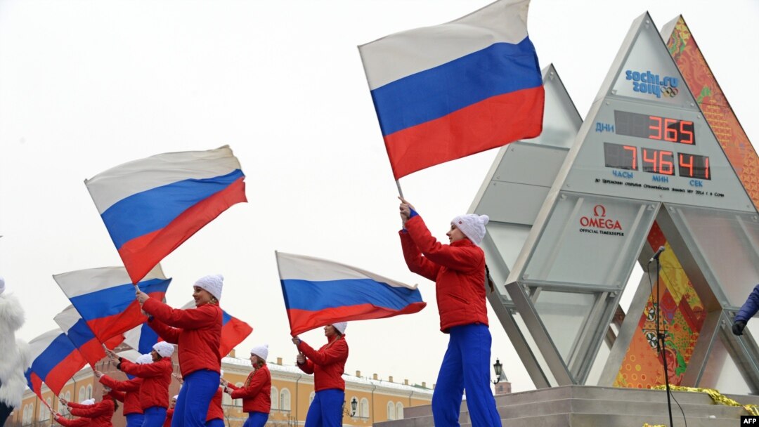 Performers wave Russian flags near the Sochi 2014 countdown clock just outside the Kremlin in Moscow in February 2013, a year ahead of the Games.