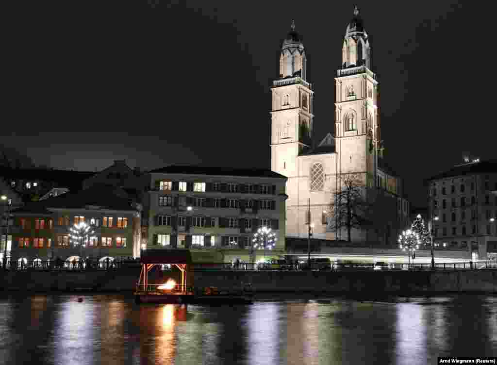 A Grossmünster templom előtt adventi gyertyaként a remény lángja ég a Limmat folyón Zürichben. &nbsp;