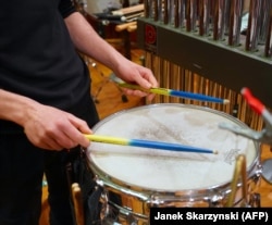 A drummer uses sticks in the colors of the Ukrainian flag during the rehearsal in Warsaw.