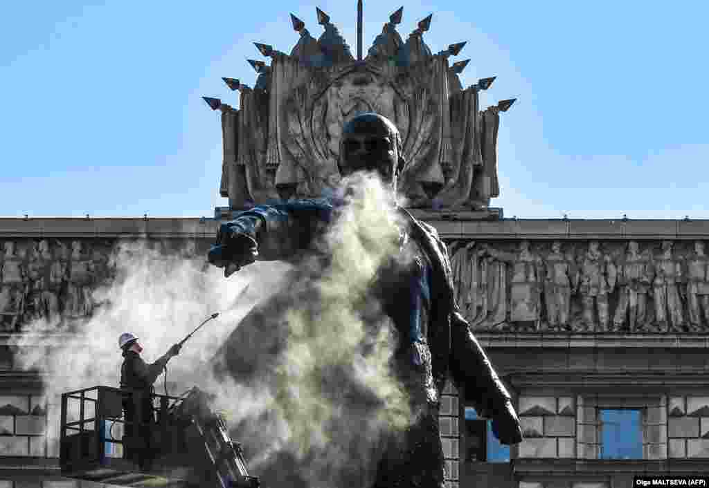 A municipal worker cleans a statue of Vladimir Lenin at Moscow Square in St. Petersburg on April 21.&nbsp;