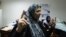A Libyan woman raises her ink stained finger after voting in Libya's parliamentary elections in Tripoli on July 7. 