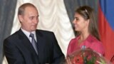 Russia -- President Vladimir Putin hands flowers to Alina Kabayeva, rhytmic gymnastics star and Olympic prize winner, after awarding her with an Order of Friendship during annual award ceremony in the Kremlin, 08Jun2001