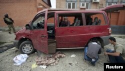 Investigators work at the site of a suicide bomb attack in the village of Sagopshi in the Malgobek district, which killed several policemen. 