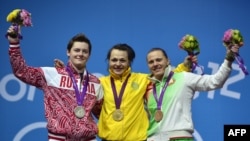 Russian weightlifter Natalya Zabolotnaya (L) after receiving her silver medal in the London 2012 Olympics poses with Belarus's Iryna Kulesha (R), the bronze medalist, and gold medalist Svetlana Podobedova from Kazakhstan (middle).
