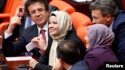 Депутаты от правящей партии Турции Нурджан Далбудак (в центре) и Севда Беязыт Каджар впервые присутствуют на сессии парламента в хиджабах. Анкара, 31 октября 2013 года. 