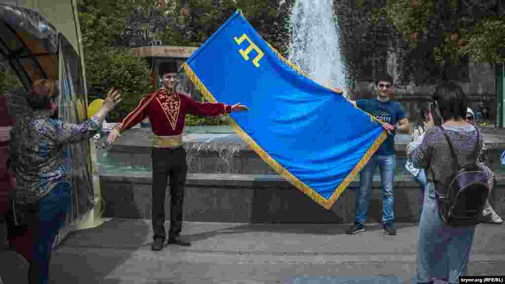 Туристы фотографируются с крымскотатарским флагом